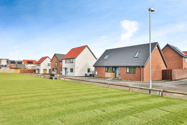 view of street scene and open space at swans nest abel homes development in norfolk