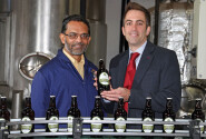 Des DSouza left of Wolf Brewery and Paul LeGrice of Abel Homes celebrate the first bottles of The Hops beer coming off the production line