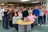 Tim Walsingham cuts his celebratory cake with Tony Abel front right and colleagues from Abel Homes2