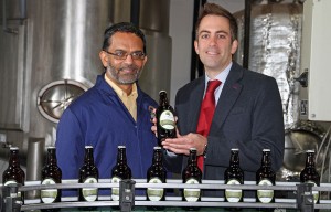 Des DSouza left of Wolf Brewery and Paul LeGrice of Abel Homes celebrate the first bottles of The Hops beer coming off the production line