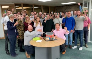 Tim Walsingham cuts his celebratory cake with Tony Abel front right and colleagues from Abel Homes2